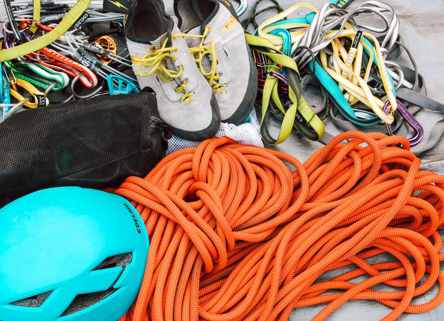 Close-up of mountain climbing gear including ropes, helmet, and harnesses for safety.